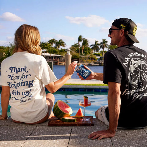 Man and woman relaxing by the pool holding a package of Road Trip mushroom gummies